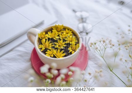 Cup With Yellow Flowers On A White Bed. Spring Background.