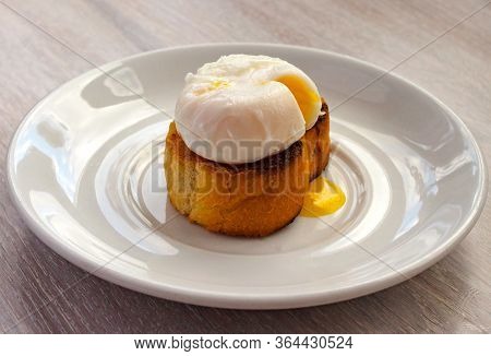 Close-up View Of Tasty Poached Egg With Liquid Yolk With Fresh Green Onion On Toastbread On White Pl