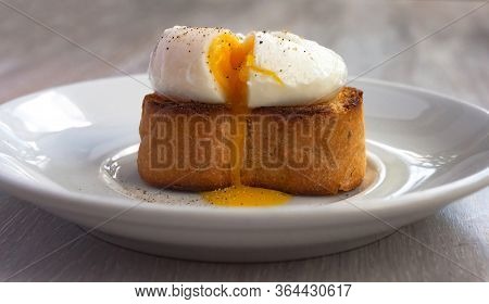 Close-up View Of Tasty Poached Egg With Liquid Yolk With Fresh Green Onion On Toastbread On White Pl