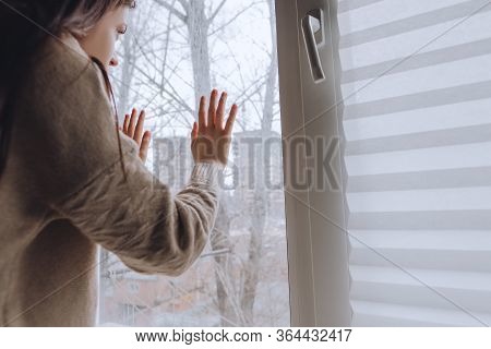 Female Touches Hands To The Window Glass, Concept Of Quarantine Or House Arrest