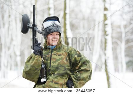 glad kvinde paintball ekstrem sport spiller iført beskyttende maske og comouflage tøj med mar
