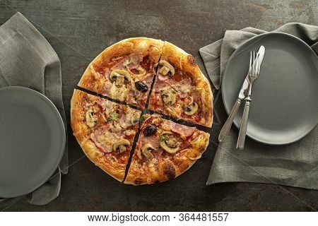 Pizza Served With Mozzarella Cheese, Ham, Mushrooms, Tomato Sauce And Fresh Basil