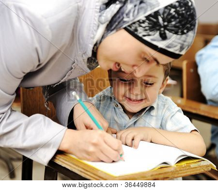 Muslimský arabský učitel pracuje s malým dítětem ve škole