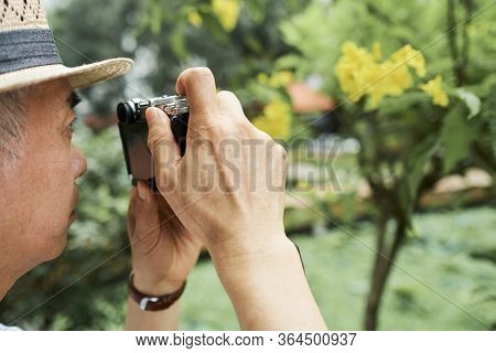 Close-up Image Of Senior Man Taking Photos Of Bloomig Tree In His Garden