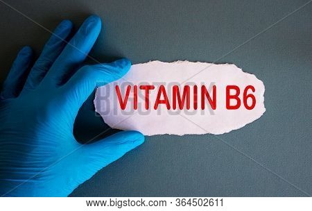 Hand In Blue Glove With White Small Paper. Concept Word Vitamin B6.