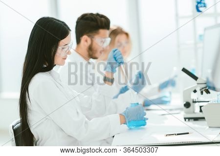 Close Up.modern Woman Sitting With Colleagues At The Laboratory