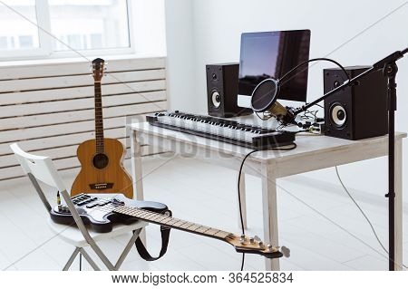 Microphone, Computer And Musical Equipment Guitars And Piano Background. Home Recording Studio Conce