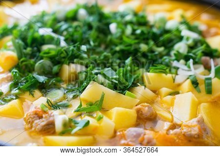 Background Stewed Potatoes With Meat Sprinkled With Fresh Herbs Close Up