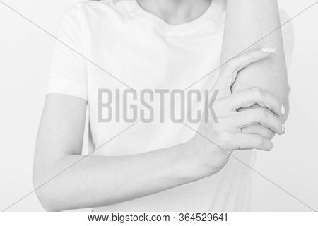 Young Girl Holding Her Elbow Joint. Pain And Inflammation In The Elbow. Black And White Picture