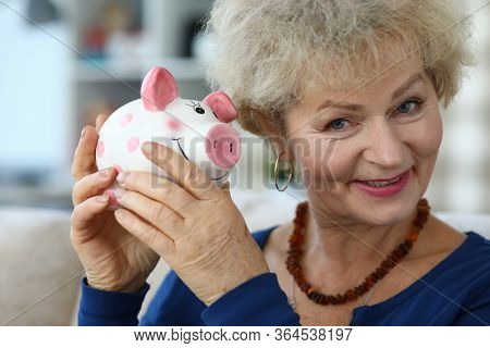 Portrait Of Senior Charming Woman Holding Piggy-bank. Elderly Female And Ceramic Container For Coins
