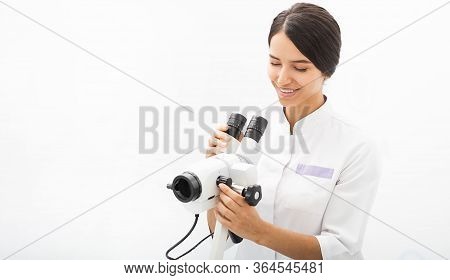 Portrait Of A Mixed Race Gynecologist Sitting In An Office Near A Colposcope. Gynecologist Professio