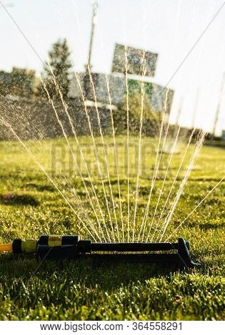 Lawn Sprinkler Spraying Water Over Green Grass. Modern Device Of Irrigation Garden Grass. Irrigation