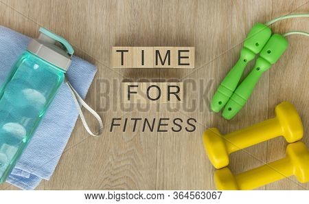 Fitness Equipment On Wooden Floor. Blocks With Words - Time For Fitness
