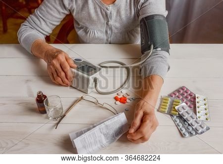 Senior Wrinkled Hands With Blood Pressure Measure Cuff, Medicine Bottle, Glass, Colorful Pills, Ther