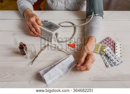 Senior Wrinkled Hands With Blood Pressure Measure Cuff, Medicine Bottle, Glass, Colorful Pills, Ther