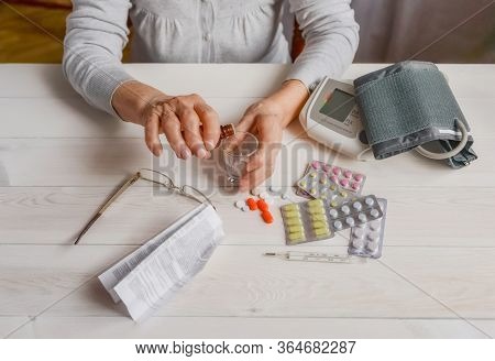 Senior Wrinkled Hands With Blood Pressure Measure Cuff, Medicine Bottle, Glass, Colorful Pills, Ther