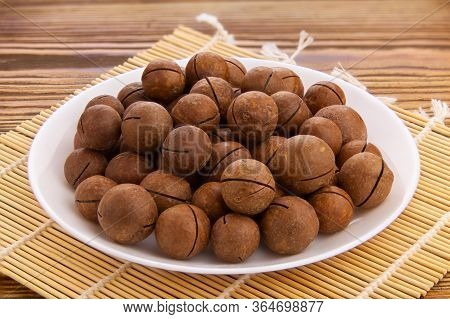 Delicious Macadamia Nuts On  Plate On  Wooden Background