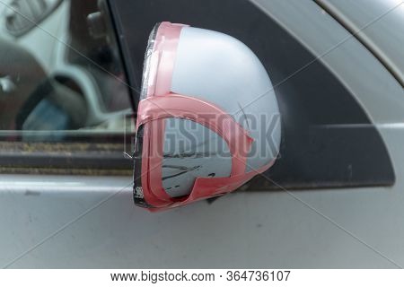 A Close Up View Of A Cars Side Mirror Has Has Been Damaged And Had Pink Duck Tape Used To Hold It To
