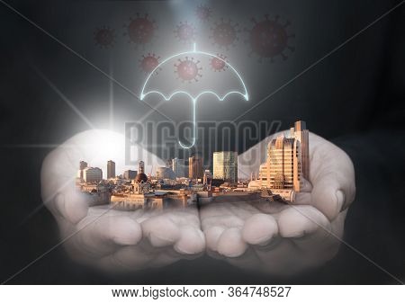 Business Man Holding Skysrapers, City Buildings Protected By An Umbrella With Covid-19 Symbols
