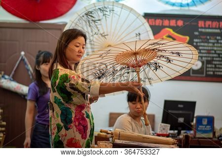 Beijing / China - July 17, 2016: Chinese Woman Holding Decorated Chinese Oilpaper Umbrella In Tradit