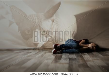 Scared Little Girl Lying On Floor Indoors. Suffering From Ailurophobia (irrational Fear Of Cats)