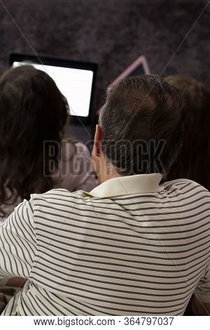 Family Doing Lessons With Children On Tablets