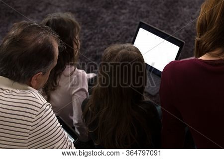Family Doing Lessons With Children On Tablets