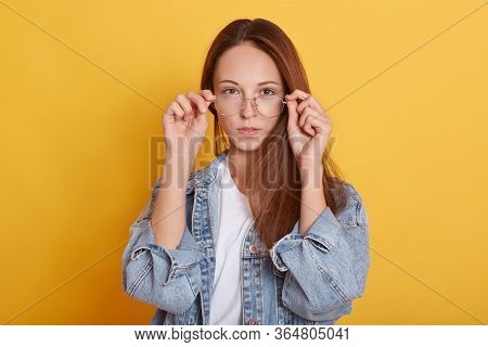 Image Of Adorable Confident Charismatic Long Haired Young Lady Putting On Spectacles, Wearing White 