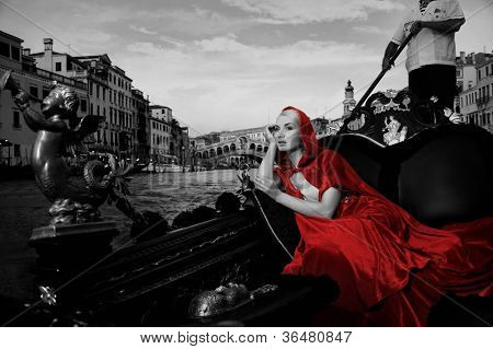 Beautifiul donna in mantello rosso cavalcando gandola