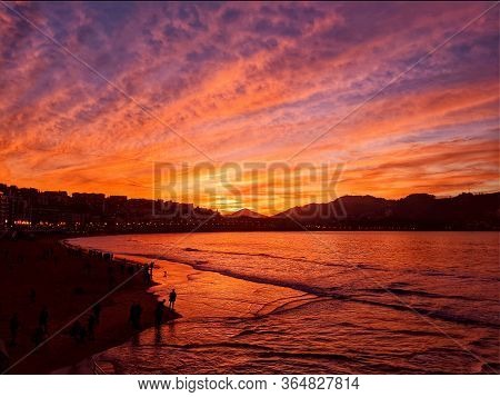 Orange Sunset On The Beach. Evening Over The Sea And Waves At The Coast.