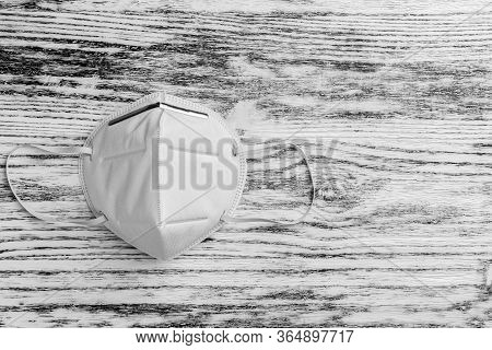 White Medical Respiratory Mask N95 On A Black White Wooden Background Close-up. Copispace. Coronavir