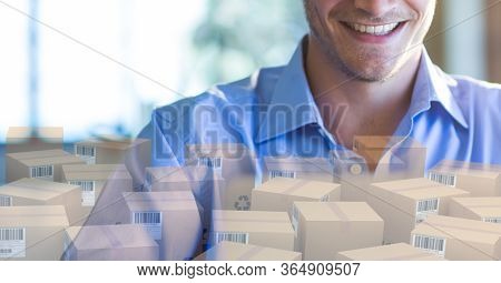 Mid section of a happy Caucasian man using laptop computer at home shopping on line, with pile of cardboard parcel boxes in front of him. Online shopping ecommerce social distancing and self isolation