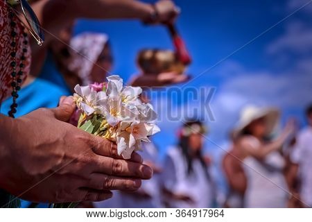 A Spiritual Girl Holding A Bouquet Of Wildflowers In Her Hands. Happy Group Of Young Friends Having 