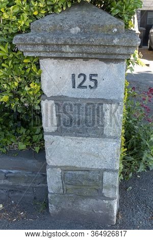 A Close Up View Of A Stone Piller Fence Outside A Home On The Main Road