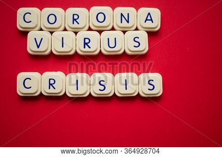 Coronavirus Crisis Written With Blocks Of A Letter Game, Over A Cherry Red Background. Illustrates T