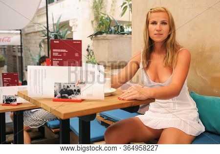 Split, Croatia - July 12, 2019:sexy Girl Drinks Segafredo Coffee In An Open-air Coffee Shop.
