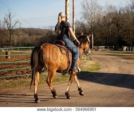 A Female Western Horse Rider/trainer, Riding A Horse