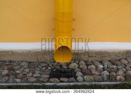 Yellow Drainpipe On The Wall Of An Old Building
