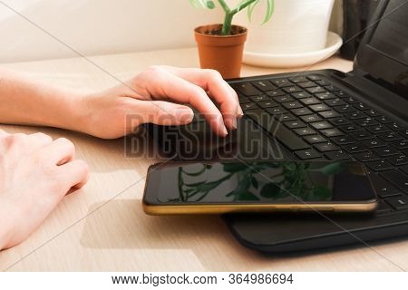 Woman Hands With Laptop And Phone On Table. Remotely Work At Home. Distance Work