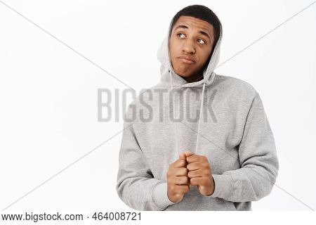 Portrait Of African American Muscline Man Looking Thoughtful And Silly, Pull Hoodie On Head, Staring
