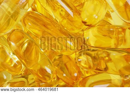 Abstract Yellow Background From Many Fish Oil Capsules. Background Or Backdrop Of Softgels. Healthy 