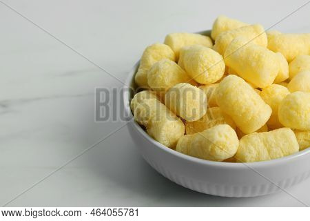 Bowl Of Delicious Crispy Corn Sticks On White Marble Table. Space For Text