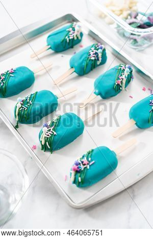 Decorating Cakesicles With Drizzled Chocolate, Chocolate Mermaid Tails, And Seashells.