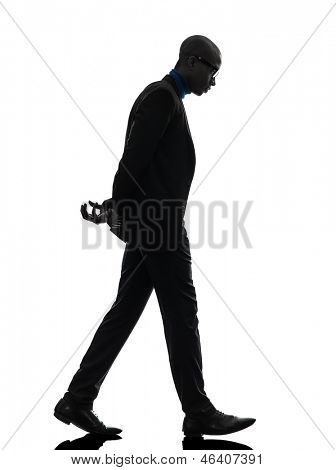 un homme noir africain marche regardant vers le bas dans le studio de la silhouette sur fond blanc