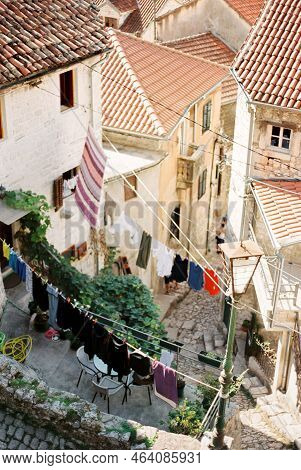 Multi-colored Linen Is Dried On The Clothesline Between Ancient Stone Houses