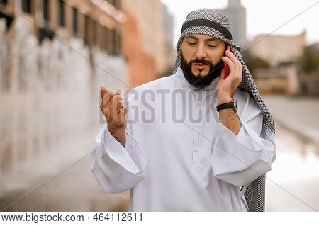 Man In Kaffiyeh And Thobe With A Phone In Hands