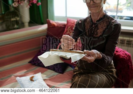 Hands Of Senior Woman Holding Thin Wooden Hoops With White Canvas