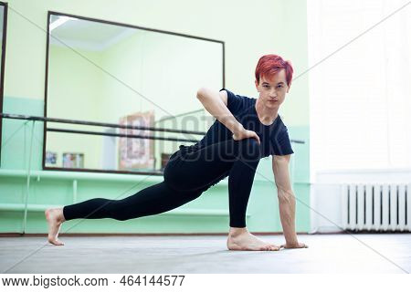 Male Dancer In The Dancing Hall. Having Stretching And Warming Up Before Intensive Dance Learning Is