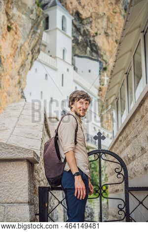 Man Tourist In Monastery Of Ostrog, Serbian Orthodox Church Situated Against A Vertical Background, 