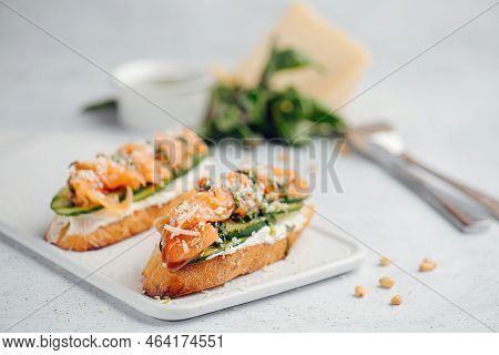 Close Up Of Two Bruschetta On A Cutting Board. Partially Blurred